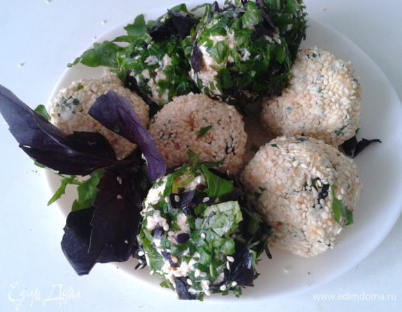 Измельчаем оставшуюся зелень, обжариваем кунжут. Одну часть шариков обвалять в кунжуте, другую в зелени. Готовые шарики подавать на руколе, присыпать кунжутом.