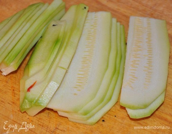 Кабачки вымыть и нарезать тонкими продольными ломтиками.