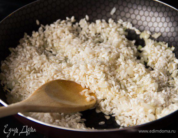 Когда лук станем прозрачным всыпаем рис. Немного обжариваем помешивая, минуту-две.  