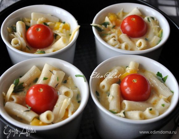 В порционные формочки выложить смесь из макарон. Заполнить формочки на ¾.
Залить макароны яичной смесью. В серединку положить по 1–ой помидорки черри и посыпать все кунжутом.
Запекать фриттату в заранее нагретой до 200 С духовке, примерно 20 минут.

