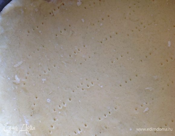 Добавить постепенно воду, и замесить гладкое тесто. Затем раскатать и перенести в смазанную сливочным маслом разъемную форму (20 см). Сделать бортики, наколоть вилкой и поставить в холодильник на время приготовления начинки.