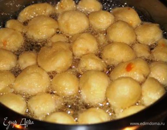 Нагреть в глубокой кастрюле масло с водой (будьте очень осторожны: оно может брызгать). Запустить половину подготовленных шариков, перемешать ложкой, чтобы не прилипли ко дну, и накрыть крышкой (накрывать надо обязательно, чтобы шарики увеличились в размере, успели прожариться и не образовывалась слишком пышная пена) 