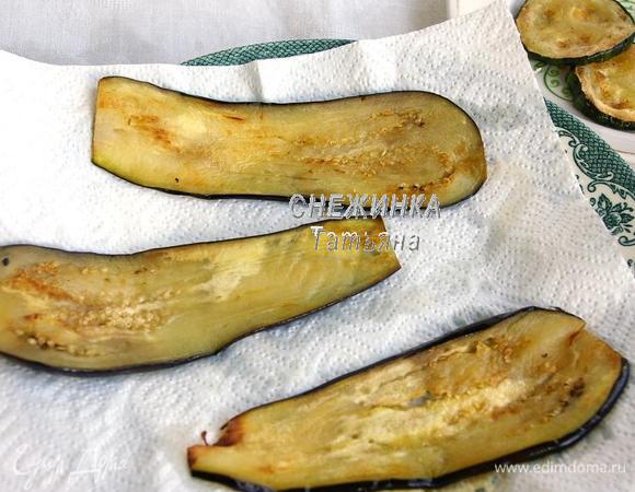 На сковороде разогреваем растительное масло, обжариваем полоски баклажана с двух сторон, не добиваемся сильной румяности, главное – чтобы полоски стали мягкими. Колечки цукини также обжариваем на другой сковороде. Выкладываем всё предварительно на бумажное полотенце, чтобы избавится от лишнего жира.