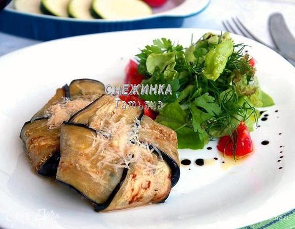 За это время приготовим салат для подачи. Зелень, салатные листья моем, обсушиваем, соединяем, выкладываем на тарелку в виде шара. Помидорки нарезаем пополам. Сбрызгиваем оливковым маслом и бальзамиком. Рядом выкладываем готовые «конвертики» из баклажана.