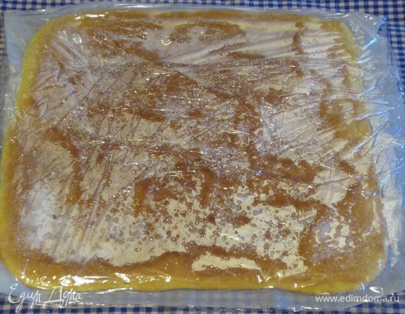 Бисквит с пергаментом положить на кухонное полотенце,посыпать оставшемся сахаром и накрыть пищевой плёнкой (таким образом внутри бисквита сохранится влажность и он не треснет при скручивании).