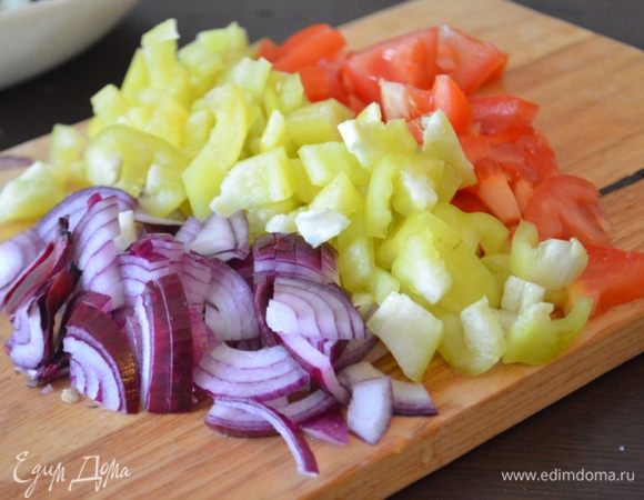 Пока баклажаны настаиваются, помыть все остальные овощи и нарезать их: лук полукольцами, чеснок и чили мелко нарубить, помидор и перец нарезать на кубики.