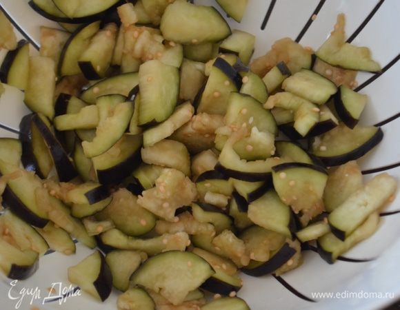 Пока первые овощи жарятся, помять руками баклажаны, выложить их в дуршлаг и промыть под водой.