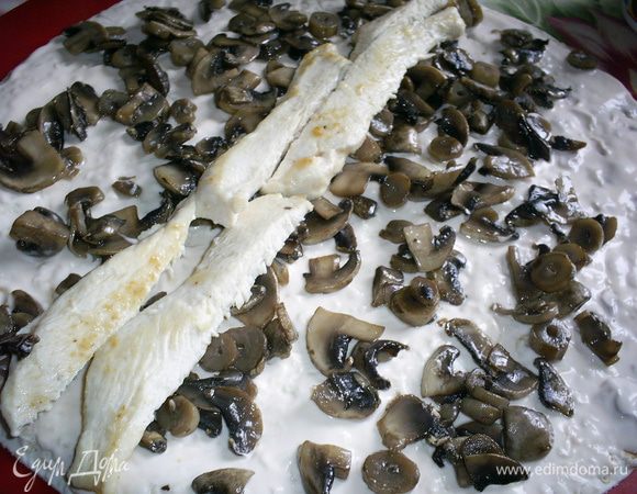 Немного остывшие грибы равномерно распределяем по смазанному сыром листу, выкладываем кусочки курицы и аккуратно сворачиваем лист рулетом. Даем настояться несколько минут и нарезаем на порционные кусочки.