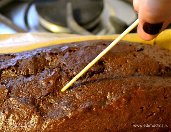 Достать кекс из духовки и, не вынимая из формы, наколоть его по всей поверхности деревянной палочкой. 