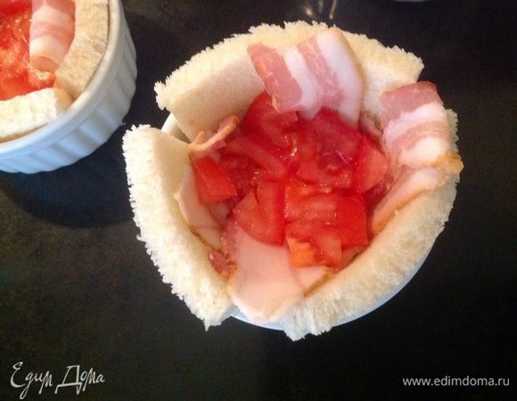 Положить 2 полоски бекона... Затем помидор, нарезанный кубиками.
