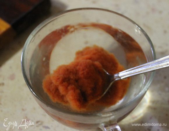 В кружечку наливаем 50-80 г воды, добавляем томатную пасту, и размешиваем ложкой, до однородной консистенции. 