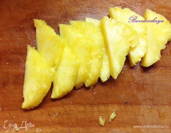 Ананас моем, обсушиваем, разрезаем на пополам, аккуратно вырезаем мякоть и нарезаем ее дольками. Если есть жесткая сердцевина, то ее необходимо вырезать.