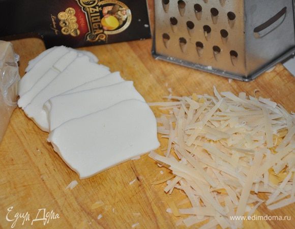 Сыр натереть на терке, моцареллу нарезать пластинками.