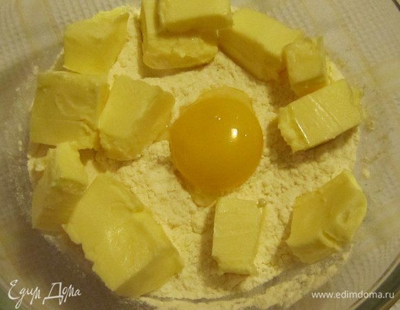Для приготовления коржа-основы в миску просеять муку, добавить сливочное масло комнатной температуры, желток и щепотку соли.