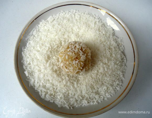 Противень застелить бумагой для выпечки. 50 грамм кокосовой стружки высыпать в блюдце. Отщипывая кусочек теста, сформовать колобок, который  окунуть в стружку (для удобства  формовки печенья, пальцы можно слегка смачивать в воде).
