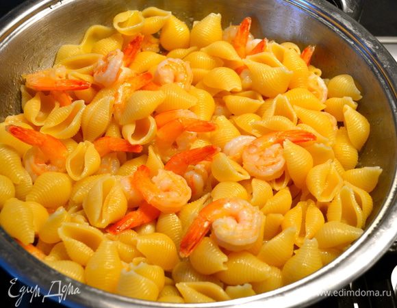 Слить пасту, сохранив два половника воды, и выложить пасту в сковороду с креветками. Добавить немного воды от варки пасты и, помешивая, подержать на огне минуты 2-3.
