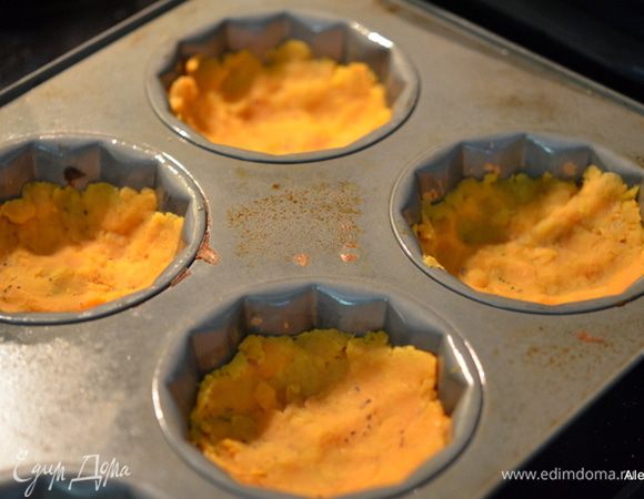 Смазать формочки для маффинов маслом, у меня крупные формочки, нестандартные. Выложить в гнезда готовый картофель и утрамбовать пальчиками. Поставить в духовку на 15 мин. Поглядываем , чтоб не подгорели.