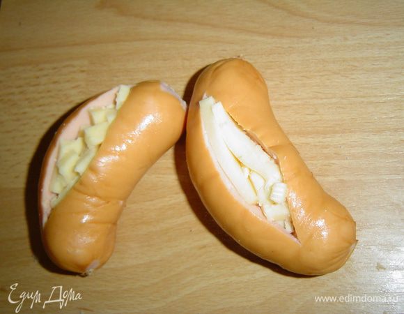 В разрез сардельки закладываем сырные брусочки,