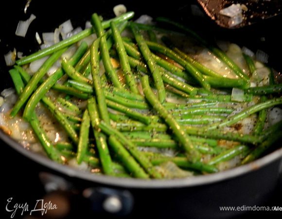 Добавить на сковороду остальную часть сливочного масла, затем как масло разойдется порезанный  лук и чеснок, примерно 2 мин. Добавить зеленую фасоль, перемешать и куриный бульон 1/2 ст. Закрыть крышкой и тушим примерно 10 мин.
