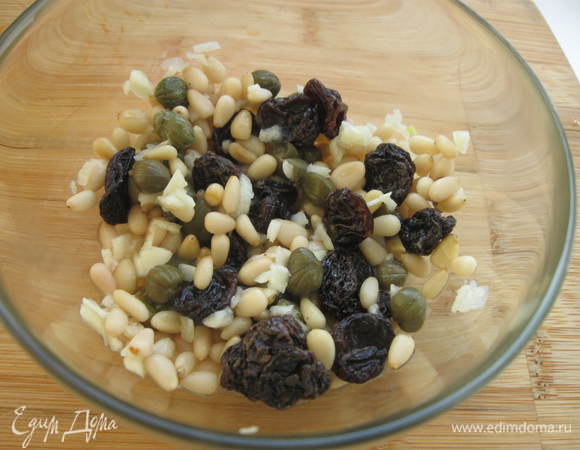 Смешать чеснок с лимонным соком и кедровыми орехами, каперсами, изюмом. Добавить эту смесь к паприке и курице. Влить масло.

