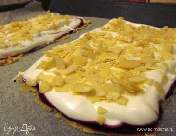 Тесто смазываем джемом, поверх выкладываем белковую массу, посыпаем миндальными лепестками и отправляем в духовку на 30-40 минут. 