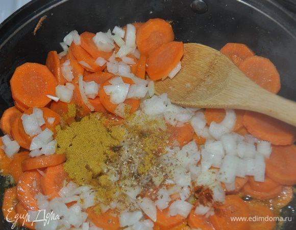 В сотейник положить сливчное масло и растопить. 
Добавить морковь, очищенный и мелко наезанный лук, кориандр, острый перец, карри, посолить и, периодически помешивая, подержать на небольшом огне в течение 10-15 минут.