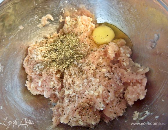 Включить духовку на 180 градусов. Из куриного филе, чеснока и хлеба сделать фарш. Добавить специи, яйцо и тщательно перемешать. 