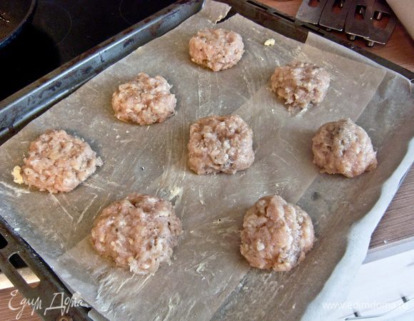 Пекарской бумагой выстелить противень. Смазать сливочным маслом. Сформировать шарики из фарша (размером как на среднюю котлету) и расположить на расстоянии 5-7 см друг от друга.