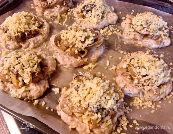 Достать ватрушки из духовки. Заполнить их грибной начинкой и сверху присыпать тертым сыром. 