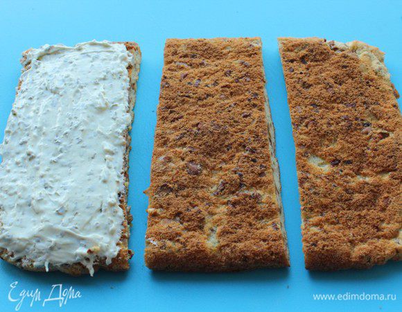 Творожный сыр перемешать с мелко нарубленной петрушкой. Полученным кремом намазать одну часть бисквита. 