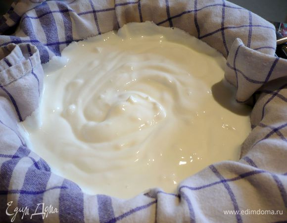 Перемешиваем йогурт с солью, ставим сито на кастрюлю, выкладываем его в два слоя хлопчато-бумажным полотенцем так, чтобы края полотенца свисали с сита, и выливаем в сито йогурт. 