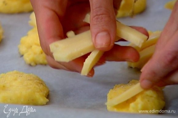 Сыр фонтина нарезать небольшими брусками и разложить сверху на оладушки.