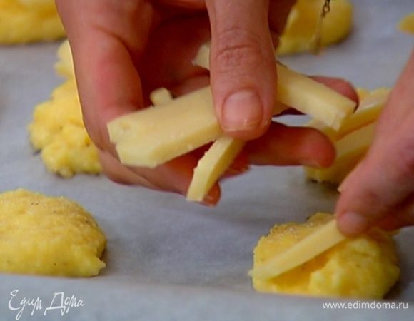 Сыр фонтина нарезать небольшими брусками и разложить сверху на оладушки.