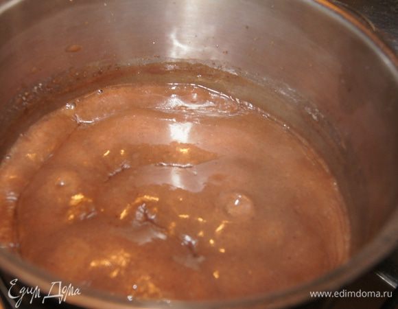 В сотейник с шоколадно-сахарной смесью влить молоко, хорошо размешать, поставить на средний огонь, постоянно помешивая, варить до загустения (5-7 минут). Блинную сковороду смазать маслом и поставить разогреваться.