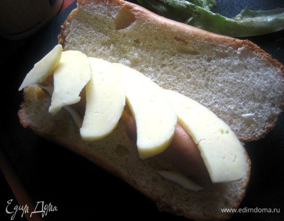 Сверху уложить ломтики обычного сыра, который плавится.