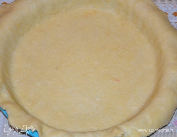 После чего смазать маслом и присыпать мукой форму, раскатать тесто до толщины 3 мм., и диаметром на 5 см. больше чем форма. Уложите тесто в форму и обрежьте лишние края теста, так чтобы они поднимались на формой на 1 см вверх. Наколоть вилкой. (можете отправить еще на 5 минуток в холодильник), уложить сверху бумагу и какой-нибудь груз (у меня фасоль), выпекать минут 15 при температуре 190 гр. С.<br />
Затем достаньте тесто из духовки, смажьте болтушкой из 1 желтка и небольшого количества холодной воды, и выпекайте еще 5 минут.