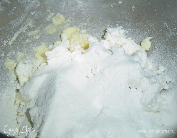 когда при этом получим крошку, то кладем творожную массу, перемешиваем, а в конце добавляем просеянную муку с содой