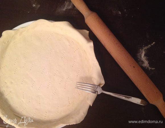 Раскраивать тесто по размеру формы. Распределить его по форме, сделав бортики.
Сделать перфорацию с помощью вилки.