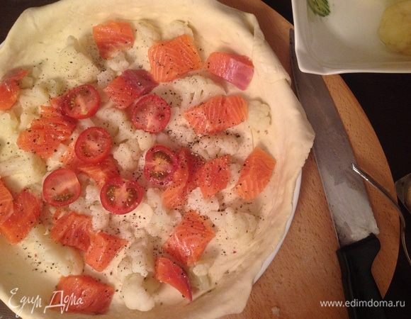 Разрезать семгу на кусочки и разделить капусту на соцветия. Натереть Пармезан на терке. (Можно купить его уже разломанный на кусочки, это еще ускорит процесс).
На дно формы выложить кусочки семги, цветной капусты и ломтиков томата. В данном случае я использовала томаты черри.