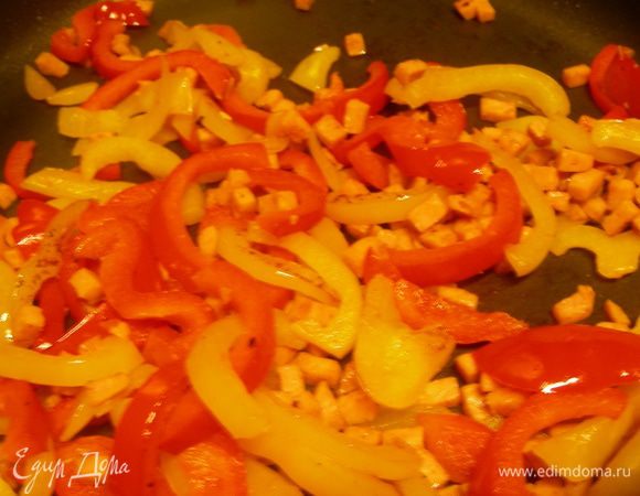 Перцы нарезаем полосочками и обжариваем на среднем огне минут 10 до мягкости. В середине приготовления (через 5 минут) добавляем кубики ветчины.
