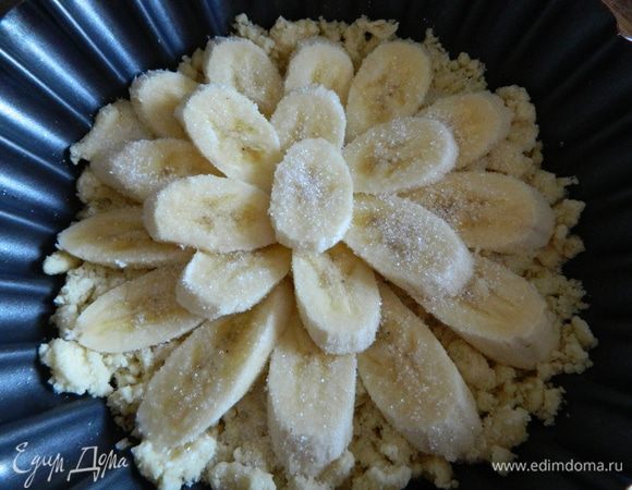 Достаем тесто из холодильника, высыпаем его в форму для выпечки, разравниваем, сверху выкладываем бананы и посыпаем их 1 столовой ложкой сахара, все отправляем в разогретую духовку на 15-20 минут.