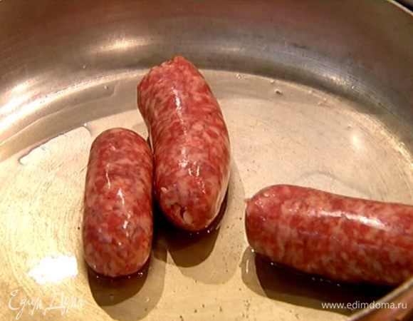 Разогреть в сковороде оливковое масло и обжарить колбаски со всех сторон, затем разрезать пополам.