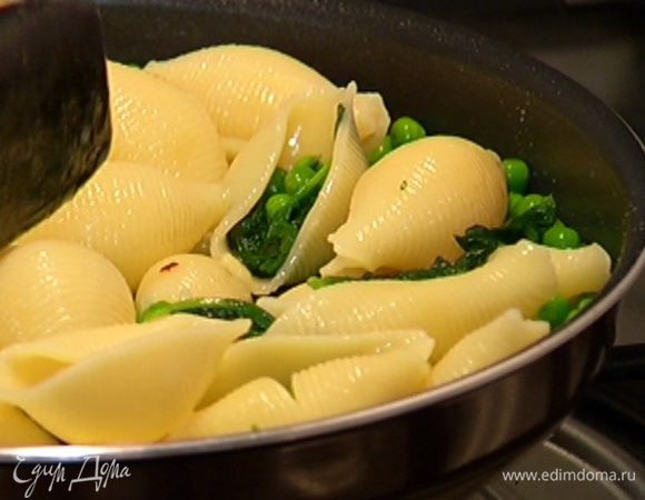Выложить в сковороду со шпинатом оставшийся горошек, перемешать, затем добавить макароны, еще раз все перемешать, поместить сковороду на огонь и немного прогреть.