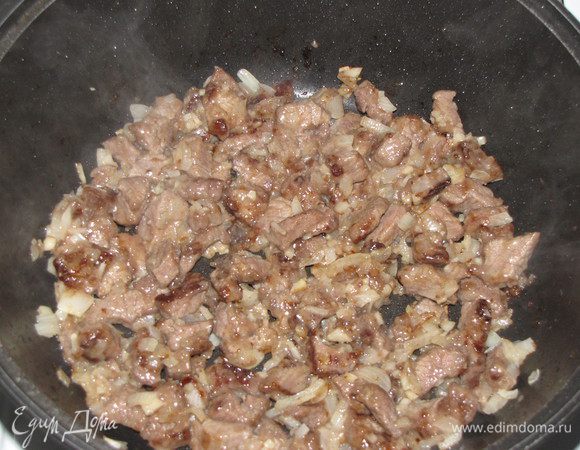 Добавить к мясу мелко нарезанный лук и чеснок и жарить еще 3 минуты.  Выложить мясо с луком в тарелку.