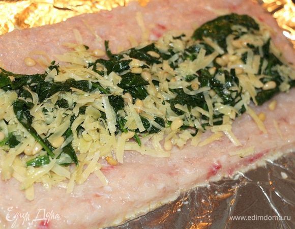 Выкладываем фарш на смазанный оливковым маслом лист фольги. Распределяем его в прямоугольный  пласт. В центр выкладываем начинку.