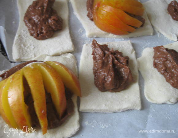 На кусочки теста положить крем. Сверху – половинки слив. Разогреть духовку до 200 градусов.  Выпекать в духовке 40 минут. 

