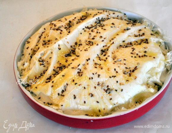 Краями теста укройте пирог сверху. Я еще положила три целых листочка фило сверху. Смазать оливковым маслом и посыпать семенами кунжута.