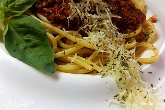 Выкладываем в тарелку спагетти и соус. Украшаем свежим базиликом и пармезаном
