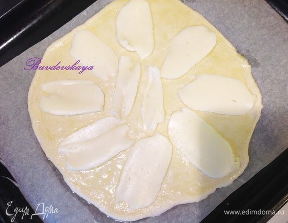 Нарежьте моцареллу тоненькими ломтиками и выложите на тесто.