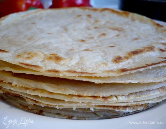 Сначала приготовим блинчики. Смешаем все ингредиенты для блинов и испечем 10 тоненьких или 8 плотных блинчиков на оливковом масле. Подрежем их неровные края ножом при помощи дна от формы или любой подходящей по диаметру посуды. Форму смажем оливковым маслом. 